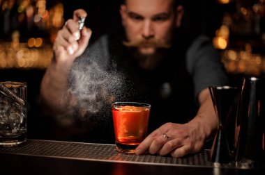 Barmen püskürtücü kullanarak bir alkol kokteyl döker