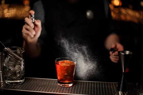 Close-up van barman die een alcohol cocktail maakt met sproeier — Stockfoto