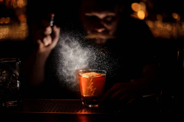 Затемненная картина бармена наливает алкогольный коктейль с помощью опрыскивателя — стоковое фото