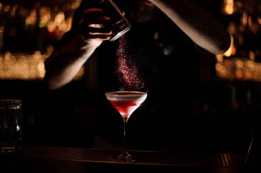 Erkek barmen bir bardak alkol kokteyl serpiştirir