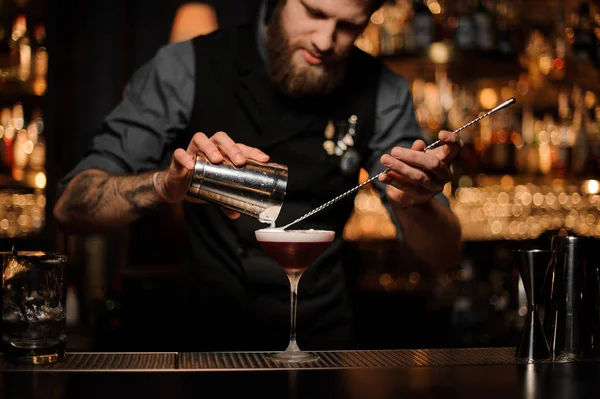 Homme barman verse cocktail en utilisant shaker et cuillère — Photo