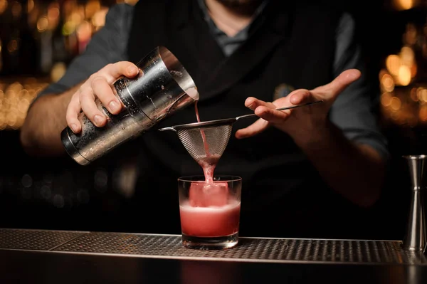 Fechar tiro de barman fazendo bebida com agitador e peneira — Fotografia de Stock