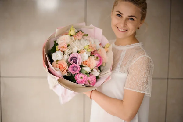 Attraktive Mädchen hält einen wunderschönen Blumenstrauß — Stockfoto