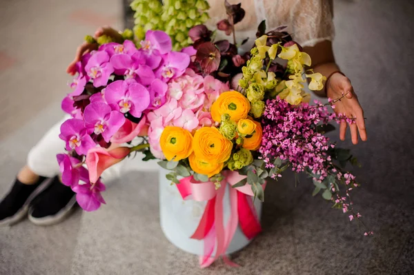 Lush bouquet in hat box on the ground