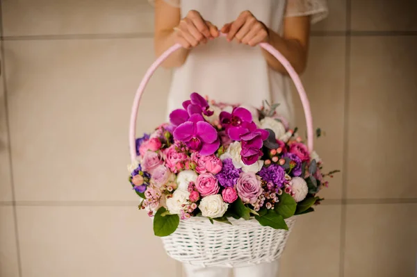 Cesta com flores diferentes em mãos de mulheres — Fotografia de Stock