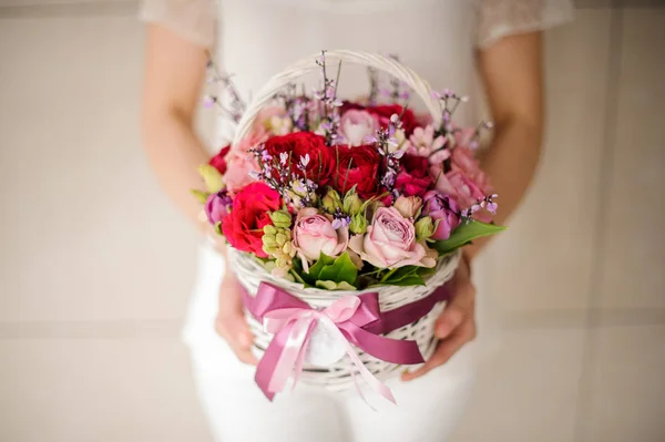 Крупним планом жінка тримає маленький кошик з квітами — стокове фото