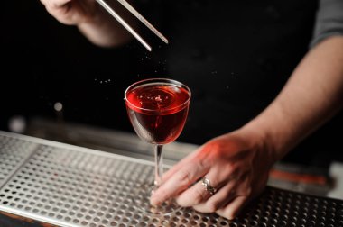 Barmen bir alkol içeceği kiraz bırakarak