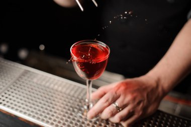 Barmen bir alkol kokteyl kiraz ekler