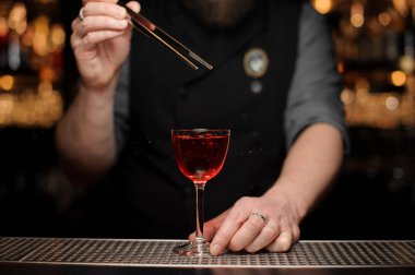 Barmen alkol içecek kiraz bırakarak yakın çekim