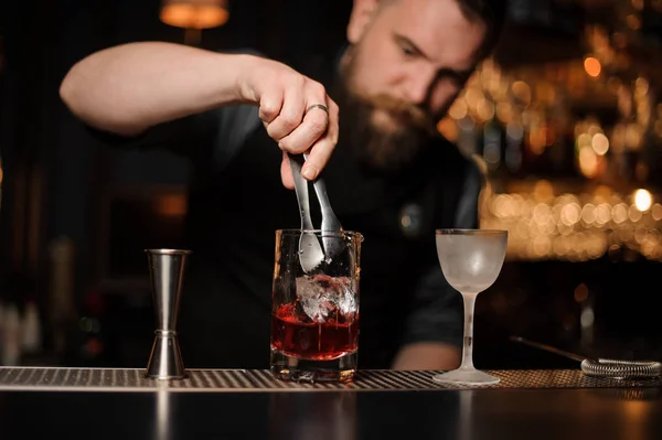 Il barista mette il cubetto di ghiaccio nel cocktail alcolico — Foto Stock