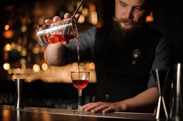 Homem barman faz uma bebida alcoólica com coador — Fotografia de Stock