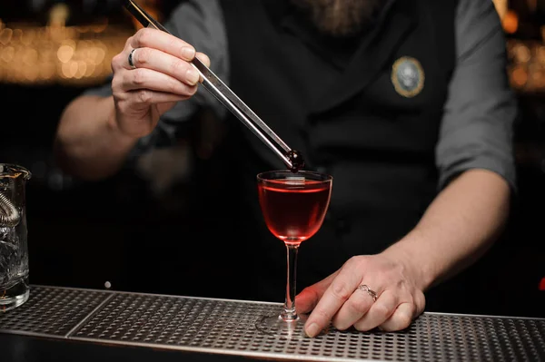 CAvvicinamento del barista che mette la ciliegia in una bevanda alcolica — Foto Stock