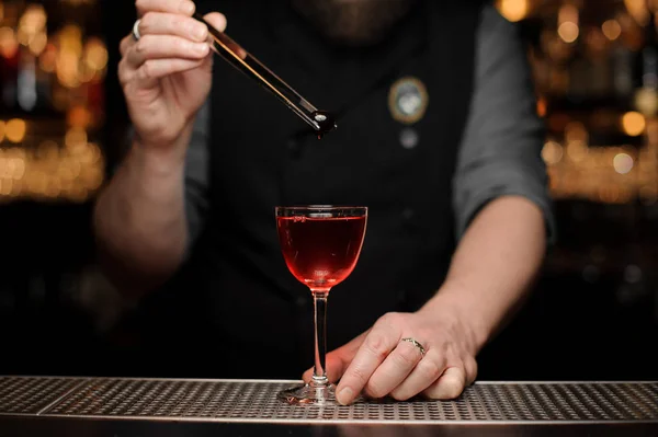 Närbild på bartender släppa körsbär i alkohol dryck — Stockfoto