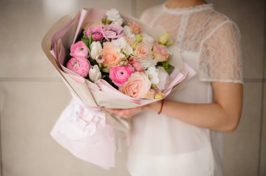 Kız ihale beyaz ve pembe çiçekler bir bahar buketi tutan