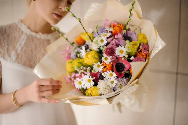 Piękna dziewczyna trzyma wiosenny bukiet przetargu różne kolorowe kwiaty — Zdjęcie stockowe