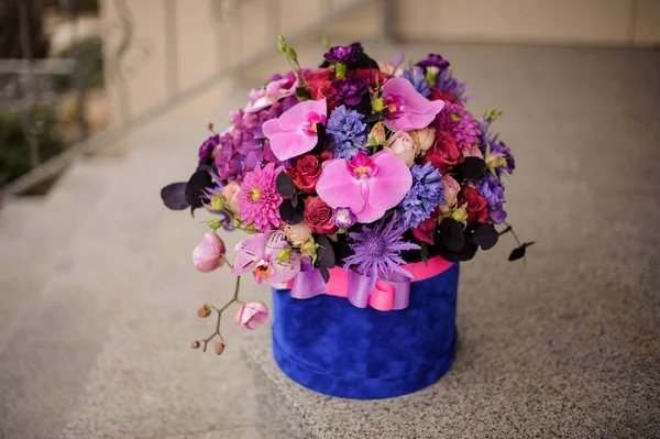 Boîte printemps bleu profond de fleurs rose tendre, violettes et bleues — Photo