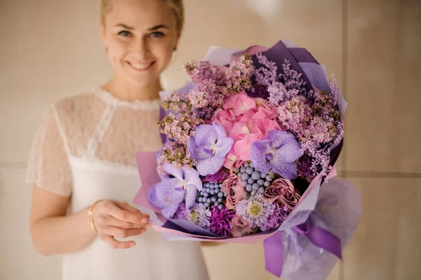 Attractive smiling girl with bouquet with irises and grape hyacinths — Stock Photo, Image