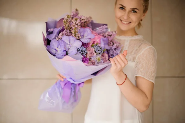 Hermosa chica sonriente con ramo de iris y jacintos de uva — Foto de Stock