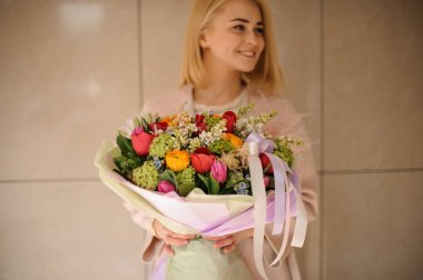 Pembe ambalaj buket tutan gülümseyen kadın