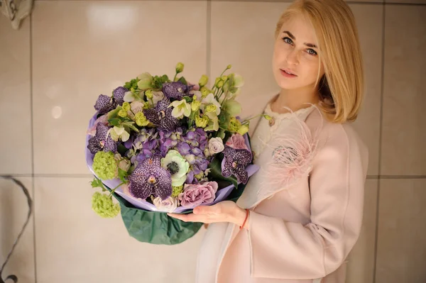 Girl in pink coat with bouquet of irises — Stok Foto