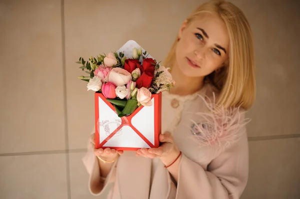 Girl with bouquet in a gift box