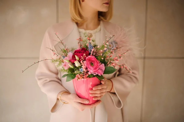 Jovem mulher segura buquê em vaso de flores — Fotografia de Stock