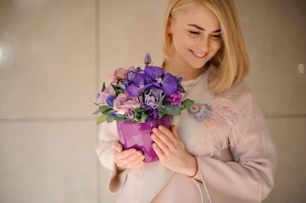 Wanita muda memegang iris dalam pot bunga — Stok Foto