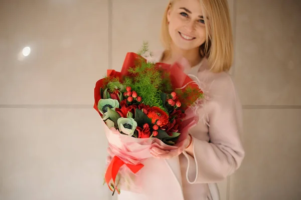 Junge Frau mit Blumenstrauß in roter Verpackung — Stockfoto
