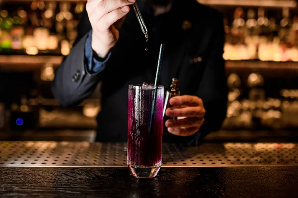 Mannelijke barman maakt alcohol cocktail met druppelaar — Stockfoto