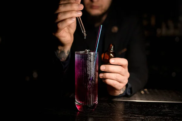 Mannelijke barman die alcohol cocktail met druppelaar maakt — Stockfoto