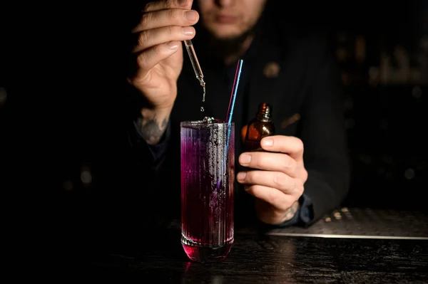 Mannelijke barman giet alcohol cocktail met druppelaar — Stockfoto