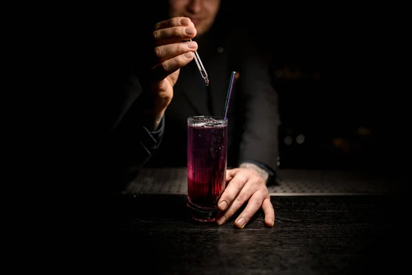 Mannelijke barman voltooit een cocktail met druppelaar — Stockfoto