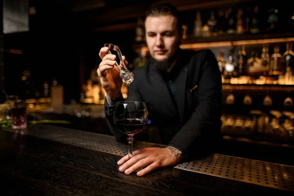 Barman colocando cubo de gelo em coquetel de álcool — Fotografia de Stock