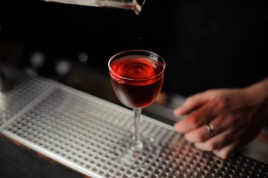 Barmen ölçüm cam bardak lezzetli bir kırmızı kokteyl dökme