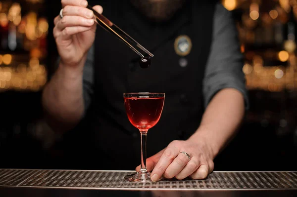 Barman ajoutant une baie rouge avec une pince à épiler au cocktail — Photo