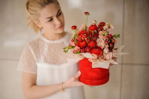 Giovane ragazza che tiene una scatola di velluto rosso di fiori scarlatti e rosa — Foto Stock