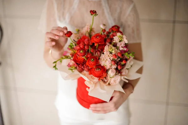 Giovane donna che tiene una scatola di velluto rosso di fiori scarlatti e rosa — Foto Stock