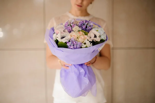 Mulher segurando um buquê de flores de primavera de cor leve concurso — Fotografia de Stock