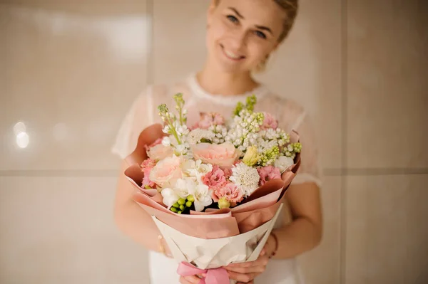 Menina sorridente segurando um buquê de flores tenras da primavera rosa e branca — Fotografia de Stock