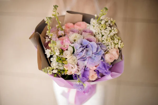 Mädchen mit einem Strauß zarter heller Farbe violette Frühlingsblumen — Stockfoto