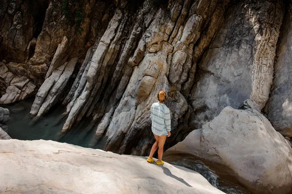 Дівчина з хвостом стоїть біля водоспаду в каньйоні — стокове фото