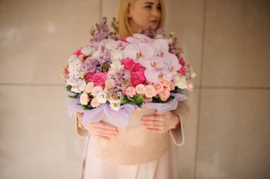 Kız ihale çok renkli pembe çiçekler büyük bir bahar kutusu tutan