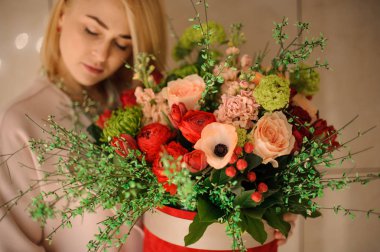 Kız ihale şeftali rengi ve tutku kırmızı çiçekler bir bahar buketi tutan