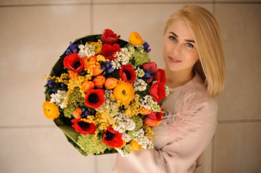 Çok renkli çiçeklerbir bahar buketi tutan güzel kadın