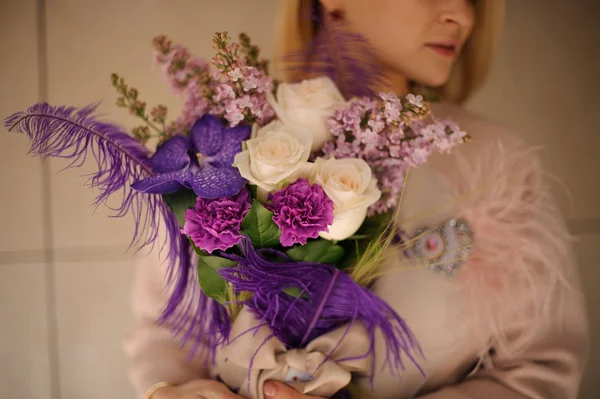 Chica sosteniendo un ramo de primavera de tiernas flores de color rosa y violeta — Foto de Stock