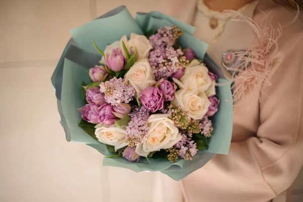 Fille tenant un bouquet de fleurs tendres de couleur violet vif et pêche — Photo