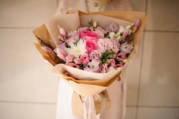 부드러운 색상의 꽃다발을 들고 코트에 소녀 핑크 꽃 — 스톡 사진