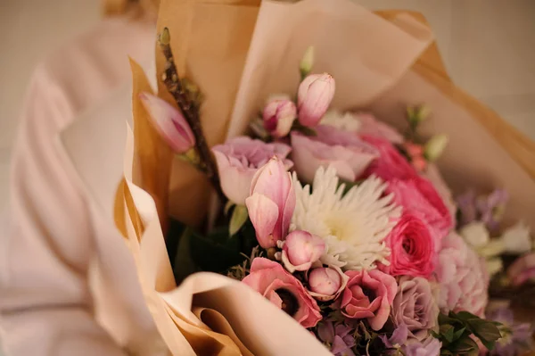 Femme dans le manteau tenant un bouquet de fleurs roses tendres — Photo