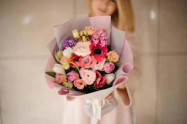 Woman in the coat holding a bouquet of tender color pink multicolored flowers — 스톡 사진