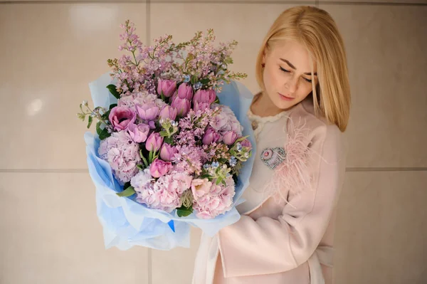 Gadis di mantel memegang karangan bunga ungu tulip ungu dan lilac — Stok Foto
